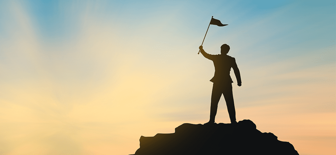 man standing on mountain with flag. Leader